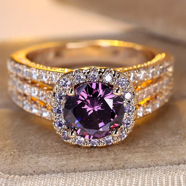Goudkleurige ring met amethistpaarse steen en rand