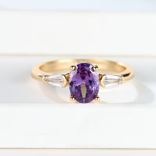 Goudkleurige ring met drie stenen en amethistpaarse steen