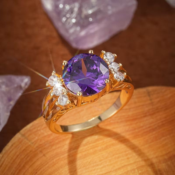 Goudkleurige split shank ring met amethistpaarse steen
