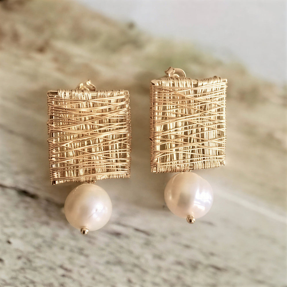 Elegante oorbellen met gouden draad en parel