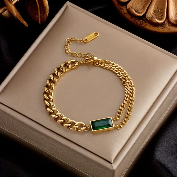Goudkleurige schakelarmband met smaragdgroen staafje