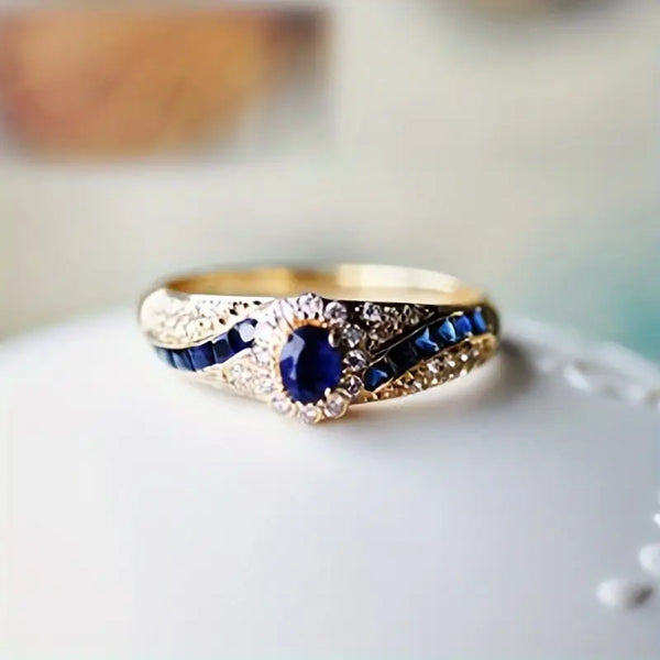 Goudkleurige ring met saffierblauwe steentjes