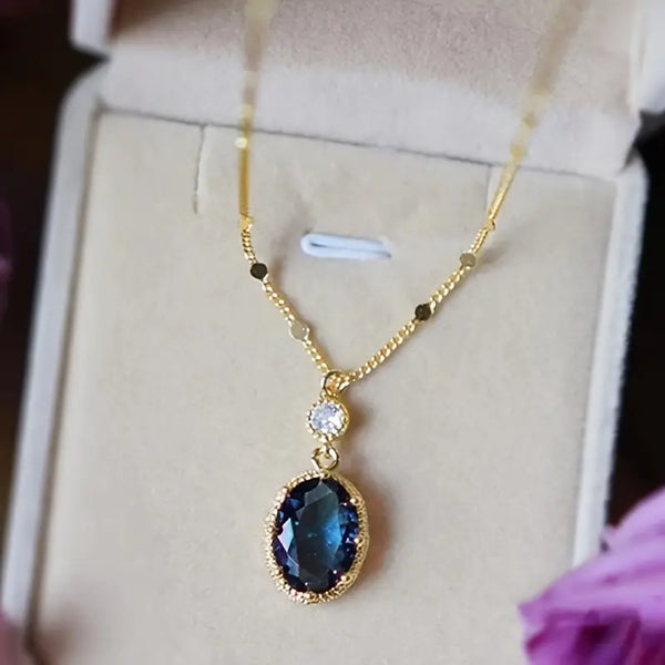 Goudkleurige ketting met ovale saffierblauwe druppel