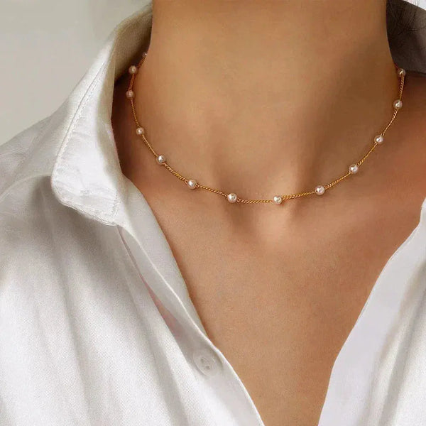 Goudkleurige schakelketting met verspreide parels