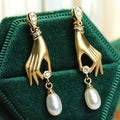 Gouden hand oorbellen met parel