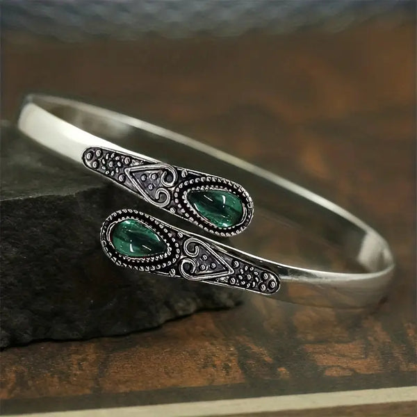 Zilverkleurige vintage bangle met smaragdgroene stenen