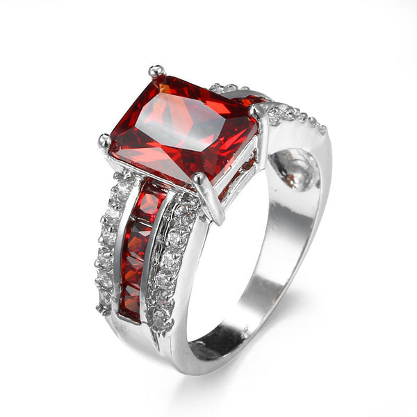 Zilverkleurige ring met robijnrode steen en gespleten ringband