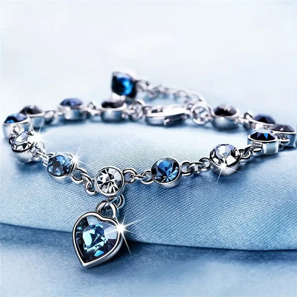 Zilverkleurige schakelarmband met saffierblauw hartje