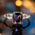 Zilverkleurige ring met amethistpaarse steen in smaragdslijpsel