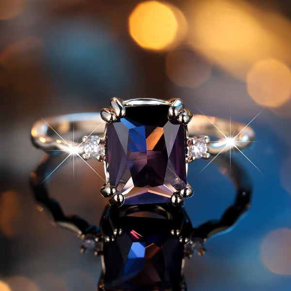 Zilverkleurige ring met amethistpaarse steen in smaragdslijpsel