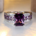 Zilverkleurige ring met amethistpaarse stenen in kanaalzetting