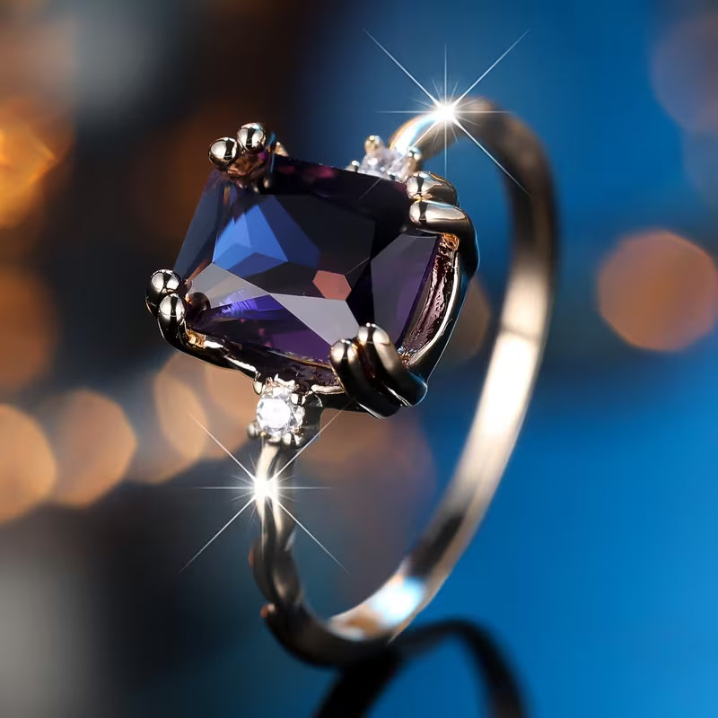 Zilverkleurige ring met amethistpaarse steen in smaragdslijpsel