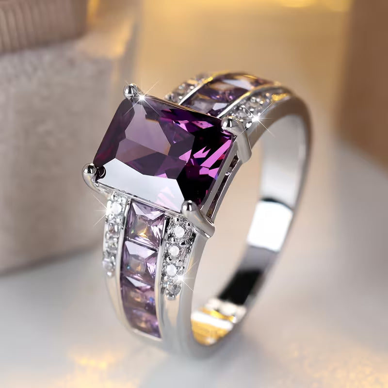 Zilverkleurige ring met amethistpaarse stenen in kanaalzetting